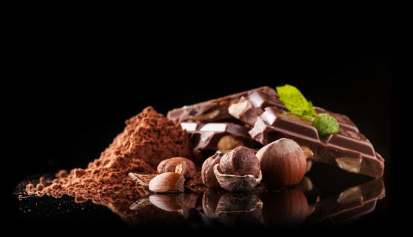 Tumpukan cokelat hazelnut di latar belakang hitam — Stok Foto