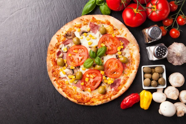 Deliciosa pizza fresca servida em pedra preta — Fotografia de Stock
