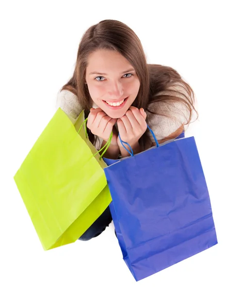 Jeune femme portant des sacs à provisions sur blanc — Photo