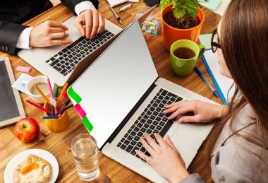 Adam ve dizüstü bilgisayarlarda çalışan kadın