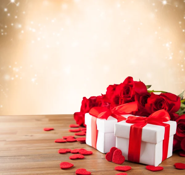 Gifts with roses on wooden table — Stock Photo, Image