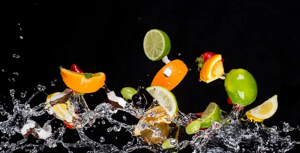 Mezcla de frutas con salpicaduras de agua en negro — Foto de Stock