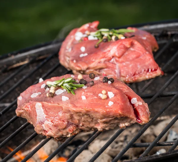 Raw beef steaks on grill — Stock Photo, Image