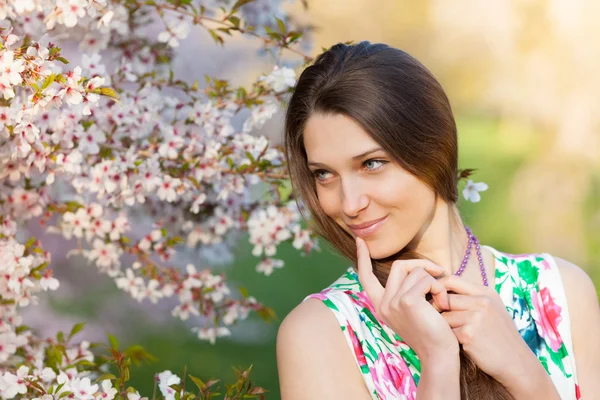 Vacker brunett kvinna i blommande orchard — Stockfoto