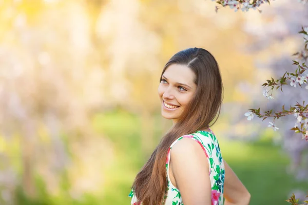 Schöne brünette Frau im blühenden Obstgarten — Stockfoto