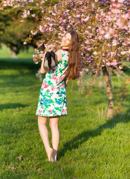 Vacker brunett kvinna i blommande orchard — Stockfoto