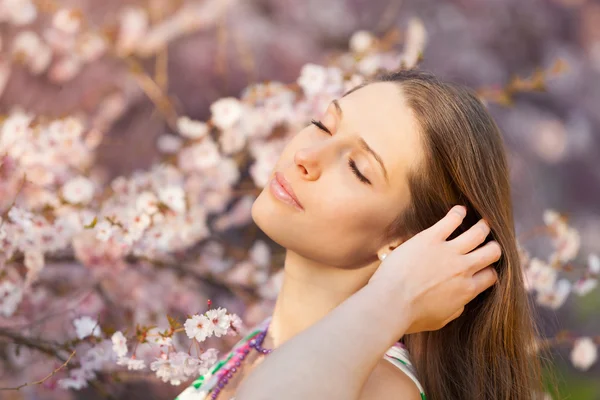 Vacker brunett kvinna i blommande orchard — Stockfoto