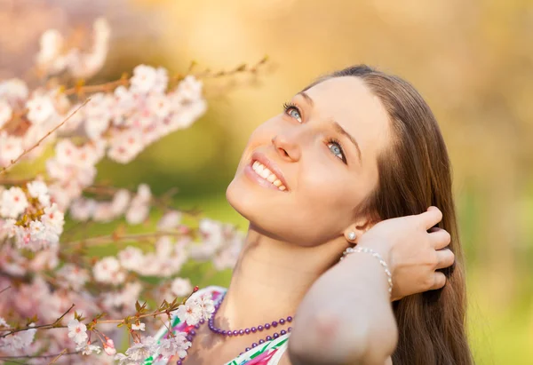 Beautiful  brunette woman in blooming orchard — Stock Photo, Image