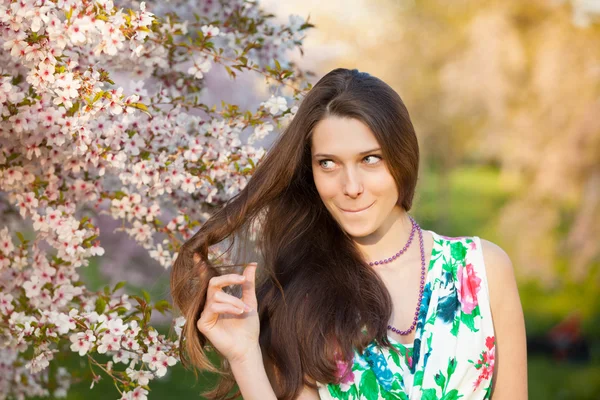 Beautiful  brunette woman in blooming orchard — Stock Photo, Image