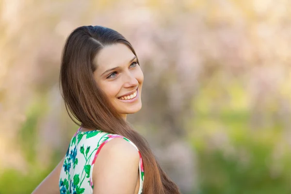 Beautiful  brunette woman in blooming orchard — Stock Photo, Image