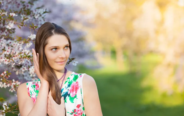 Schöne brünette Frau im blühenden Obstgarten — Stockfoto
