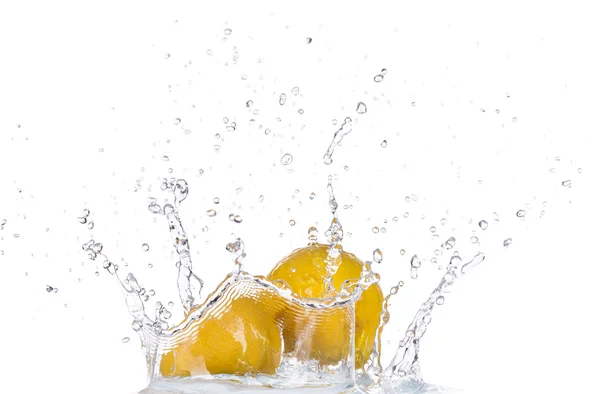 Свежий лимон в брызгах воды на белом фоне — стоковое фото