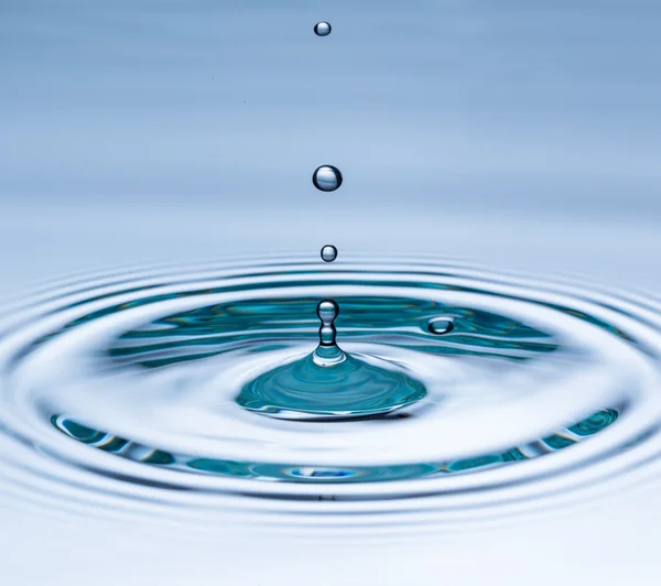 Drop of water falling into water surface — Stock Photo, Image