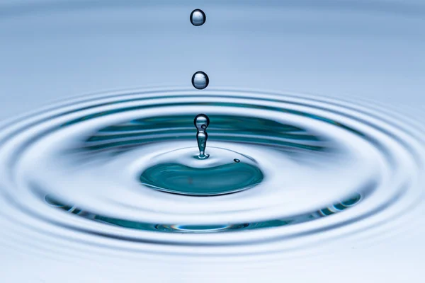 Drop of water falling into water surface — Stock Photo, Image