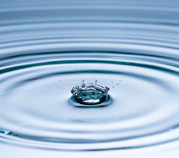 Drop of water falling into water surface — Stock Photo, Image