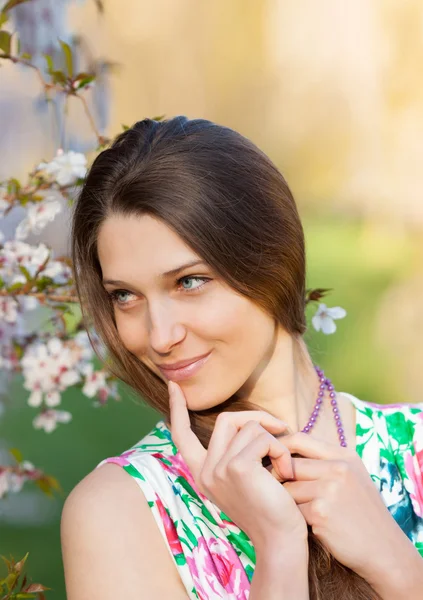 Vacker brunett kvinna i blommande orchard — Stockfoto