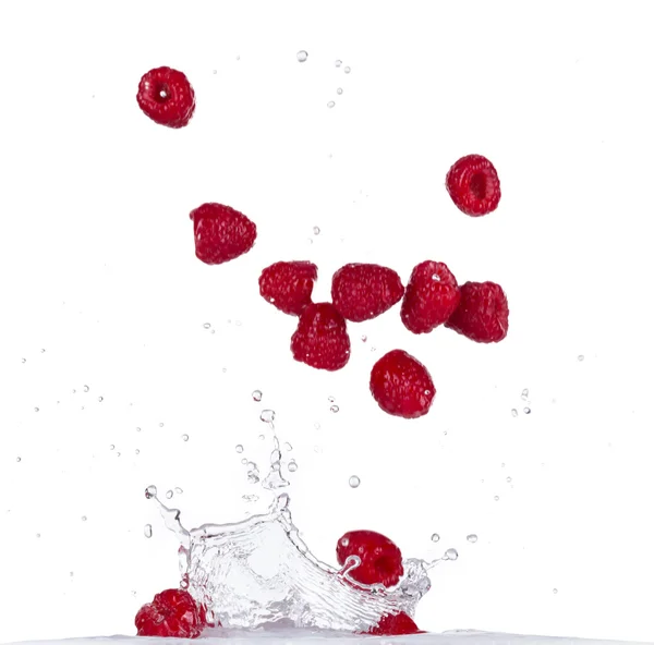 Himbeeren im Wasserspritzer auf weißem Hintergrund — Stockfoto