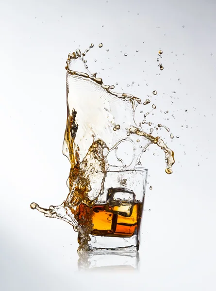 Whiskey drink with splash and ice cubes — Stock Photo, Image
