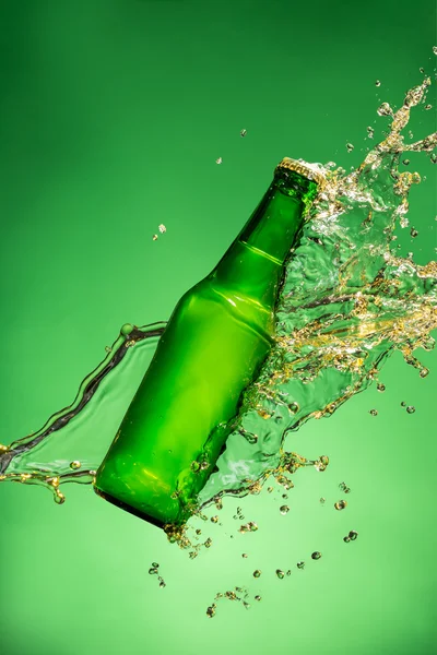 Bottle of beer with splash, on green background — Stock Photo, Image