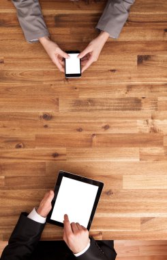 Adam ve akıllı telefon ve tablet üzerinde çalışan kadın