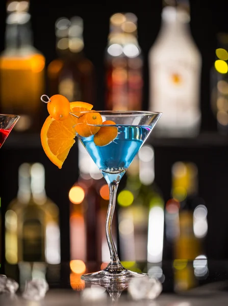 Martini drink served on glass table with ice cubes — Stock Photo, Image