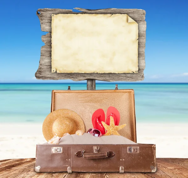 Blank sign with old suitcase on wooden planks — Stock Photo, Image