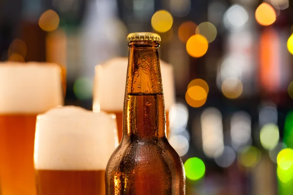 Brocca di birra con bottiglia servita sul bancone del bar — Foto Stock