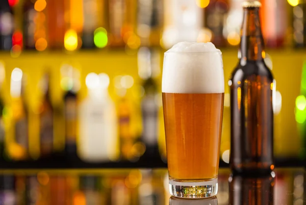 Jug of beer with bottle served on bar counter