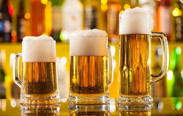 Jugs of beer served on bar counter — Stock Photo, Image