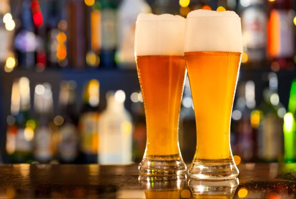 Jugs of beer served on bar counter — Stock Photo, Image