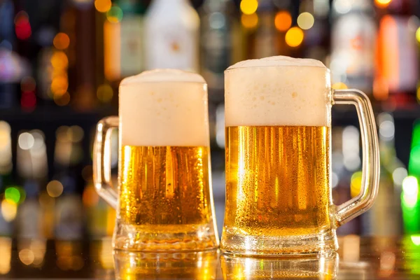 Boccali di birra serviti sul bancone del bar — Foto Stock