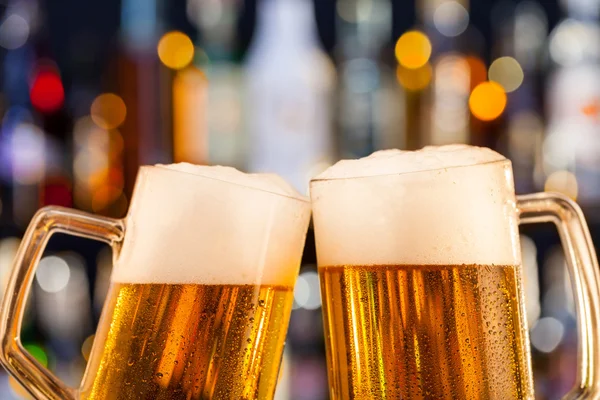 Jugs of beer served on bar counter — Stock Photo, Image