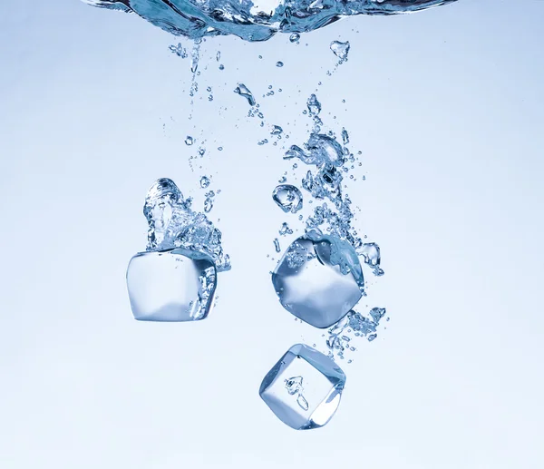 Cubos de hielo en salpicaduras de agua — Foto de Stock