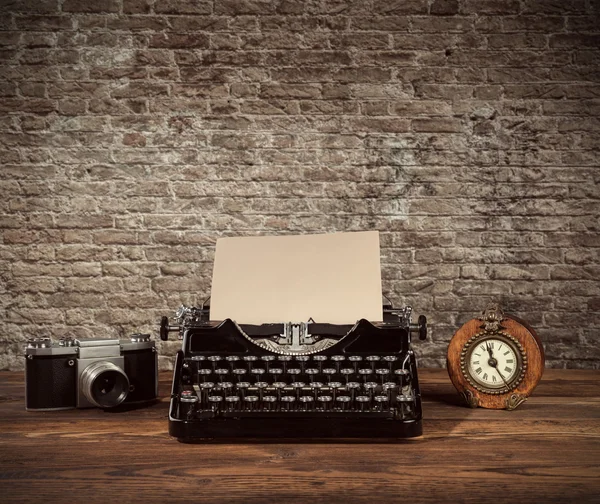 Retro typewriter, alarm-clock and camera on wood — Stockfoto