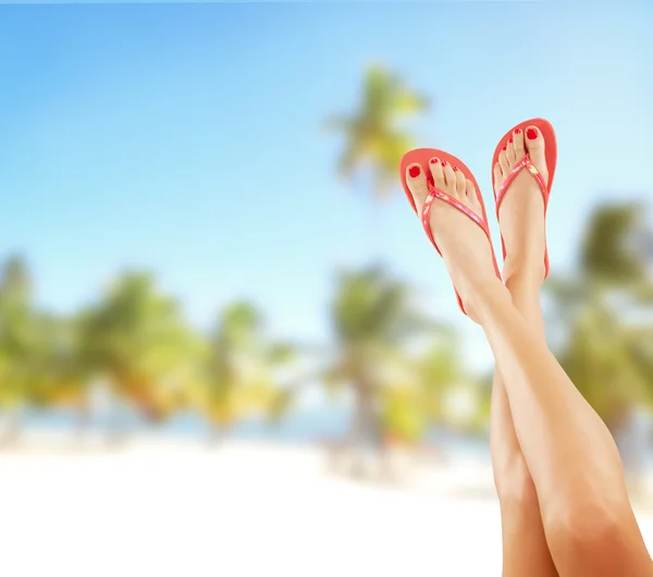 Slim female legs on sandy beach — Stock fotografie