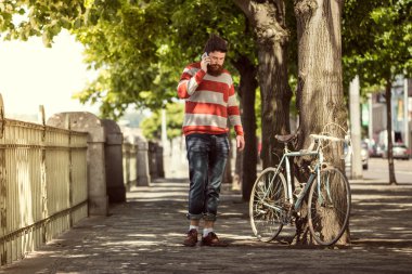 Trendy hipster young man using smart phone