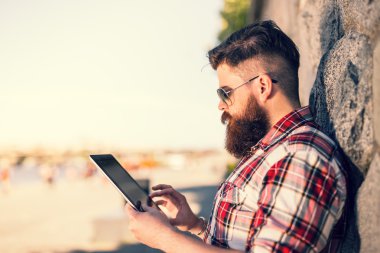 Trendy hipster young man with tablet
