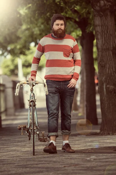 Jovem hipster na moda com bicicleta — Fotografia de Stock