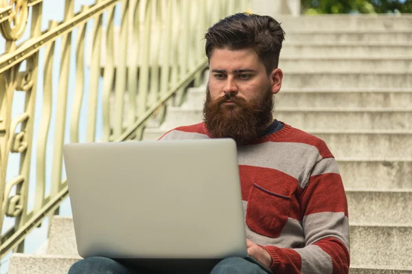 Trendy hipster young man with laptop — Stock fotografie