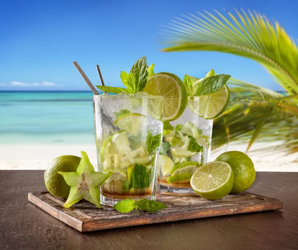 Літні напої з пляжем на фоні — стокове фото