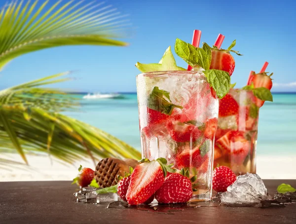 Летние напитки на фоне размытого пляжа — стоковое фото