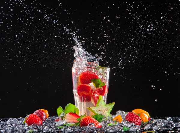 Exotic drink with splash on black background — Stock Photo, Image