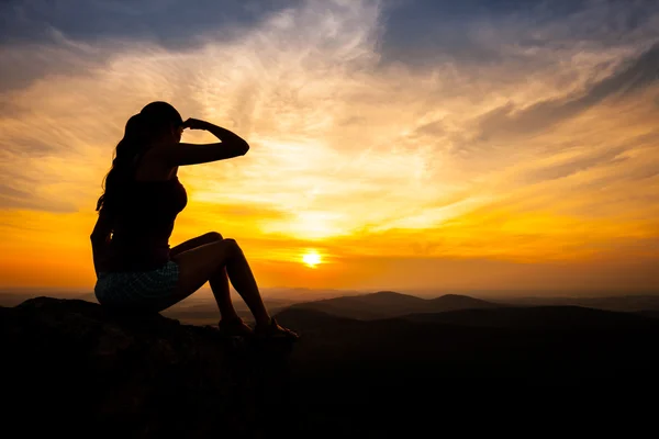 Single adult woman silhouette on rock — Stock Photo, Image