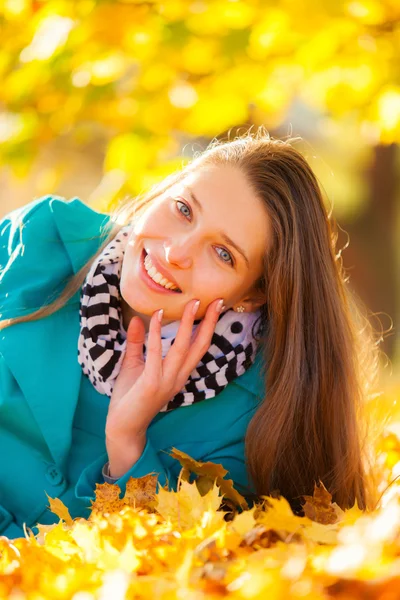 Beautiful girl lying in autumn leaves — Stock Photo, Image