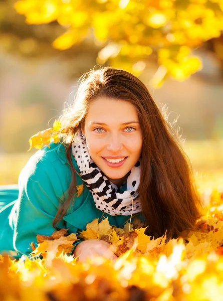 美丽的女孩躺在秋天的落叶 — 图库照片