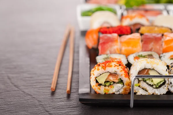 Kousky sushi hůlkami — Stock fotografie