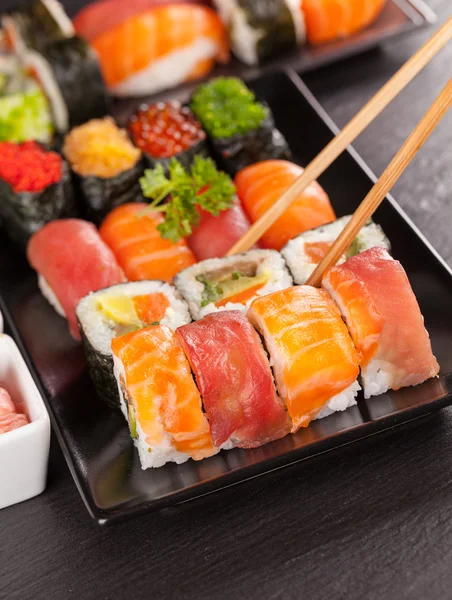 Kousky sushi hůlkami — Stock fotografie