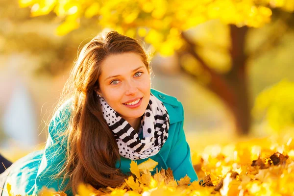 Beautiful girl lying in autumn leaves — Stock Photo, Image