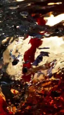 Meyve çayını hortum şeklinde suya dökmek çok yavaş bir hareket. Yüksek hızlı sinema kamerasıyla çekildi, 1000fps. Dikey görünüm oranı.