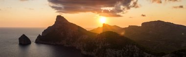 İspanya Mallorca, Cap de Formentor 'un tepelerinde altın gün batımı. Nefes kesici Akdeniz manzarası. Kayalık sahilde güneş ışınları çarpıcı yüksek çözünürlükte..